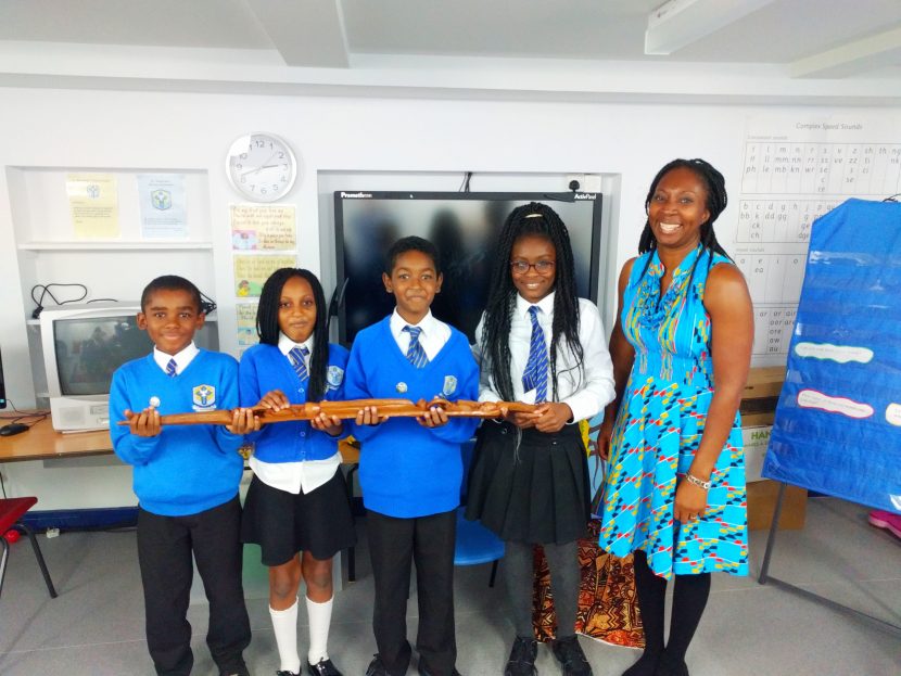Year 5 pupils holding an African staff with Wendy Shearer - Storyteller