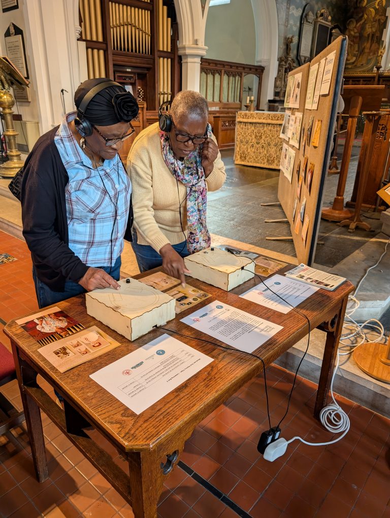 Two women listening to Oral History interviews at All Saints Church